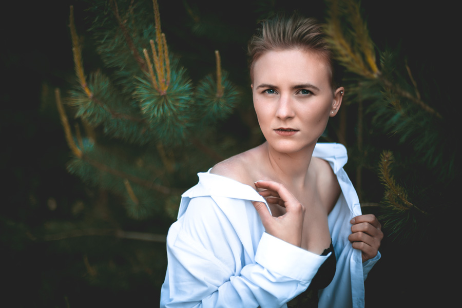 Junge Frau steht vor einer Kiefer von Fotografin Metelen